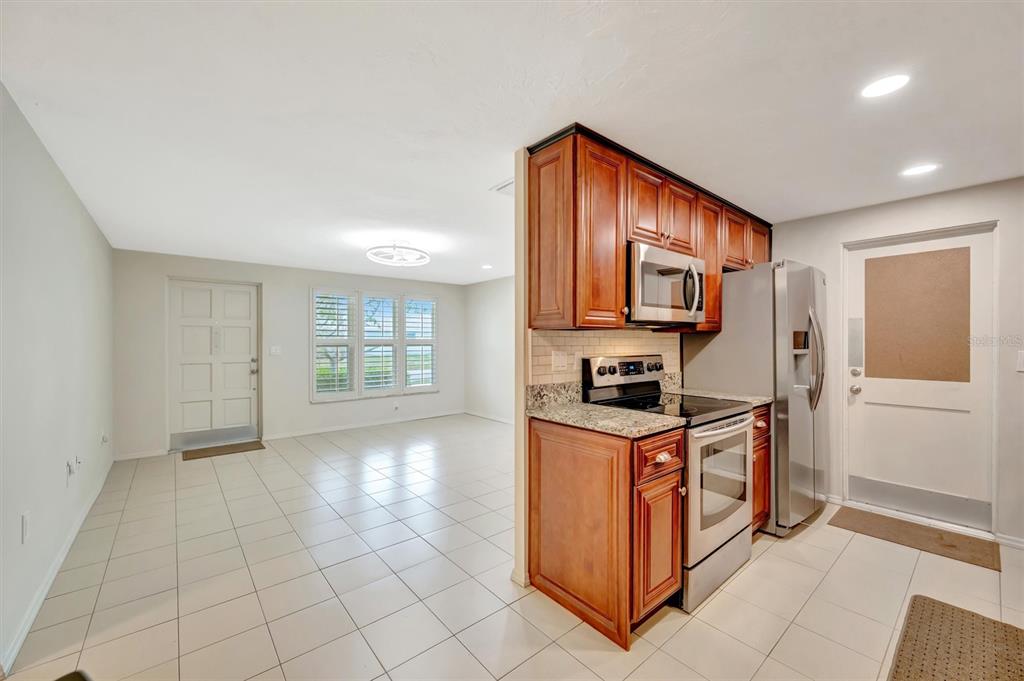4478 Coco Ridge Circle Sarasota, FL 34233 - Photo 18 of 85 a kitchen with stainless steel appliances granite countertop a stove a sink and a refrigerator