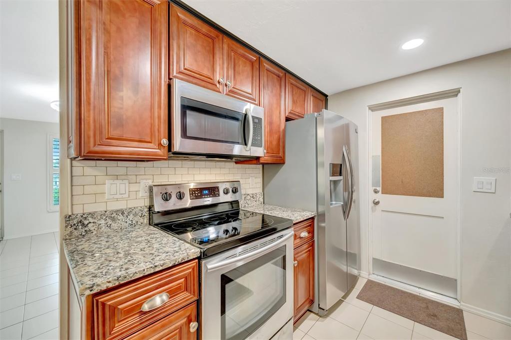 4478 Coco Ridge Circle Sarasota, FL 34233 - Photo 19 of 85 a kitchen with stainless steel appliances granite countertop a stove microwave and refrigerator