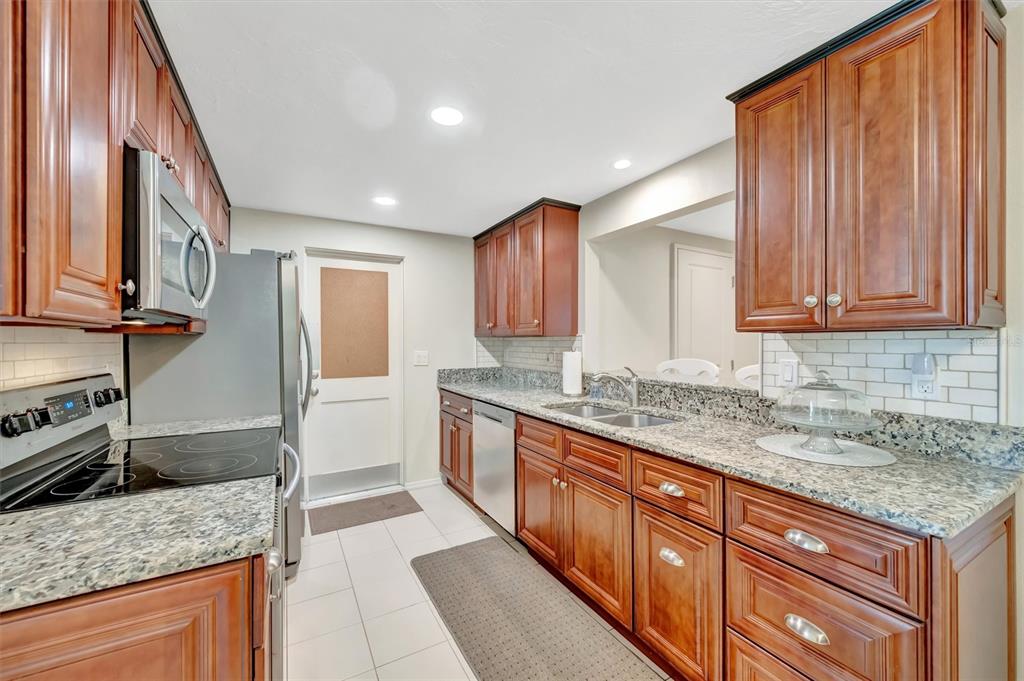 4478 Coco Ridge Circle Sarasota, FL 34233 - Photo 20 of 85 a kitchen with stainless steel appliances granite countertop a sink stove and refrigerator