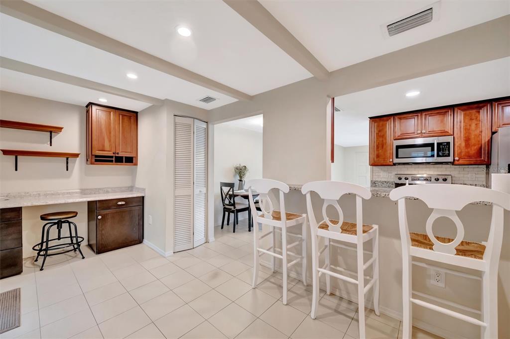 4478 Coco Ridge Circle Sarasota, FL 34233 - Photo 31 of 85 a kitchen with stainless steel appliances granite countertop a stove top oven a sink a dining table and chairs