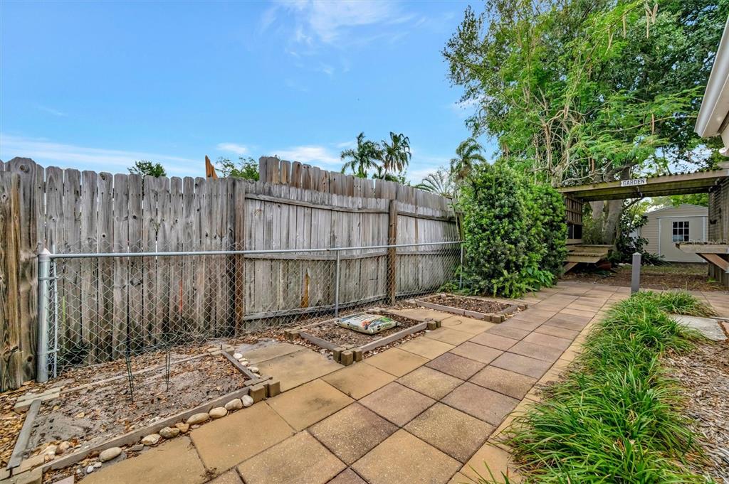 4478 Coco Ridge Circle Sarasota, FL 34233 - Photo 60 of 85 a backyard of a house with plants and wooden fence