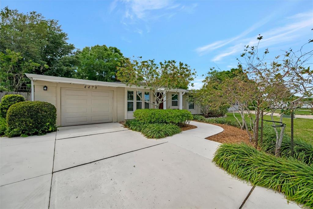 4478 Coco Ridge Circle Sarasota, FL 34233 - Photo 83 of 85 a view of a house with a yard and potted plants
