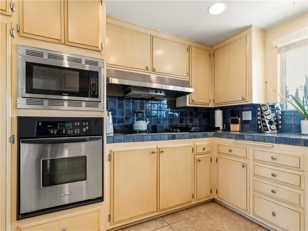 a kitchen with stainless steel appliances granite countertop a stove microwave and cabinets