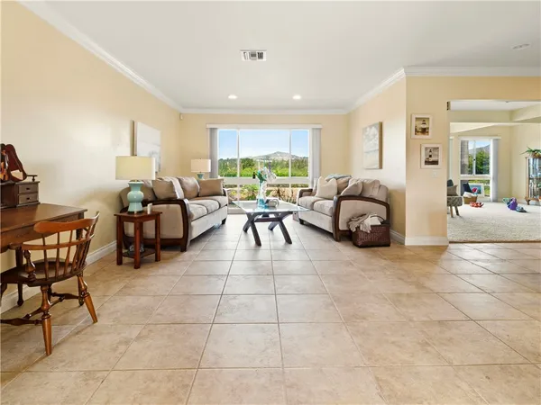 a living room with furniture a dining table and a large window