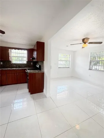 a large kitchen with granite countertop a stove a microwave a sink and dishwasher