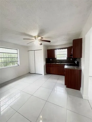 a kitchen with granite countertop a stove a sink and a refrigerator