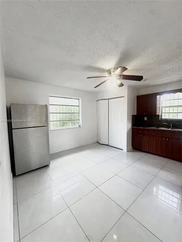 a view of a kitchen with a sink and a refrigerator