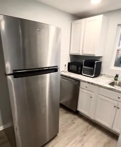 a view of a refrigerator in kitchen and empty room