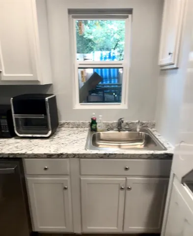 a kitchen with granite countertop a sink and a stove
