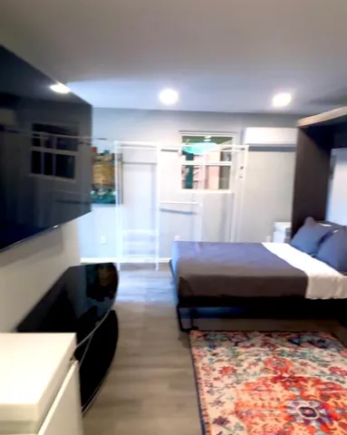 a living room with a bed furniture and a flat screen tv