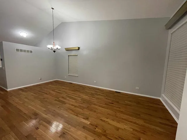 a view of a room with wooden floor and ceiling fan