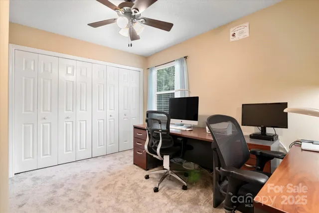 a view of a workspace with furniture and a window