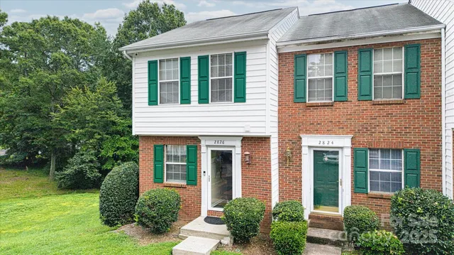 front view of a brick house with a yard