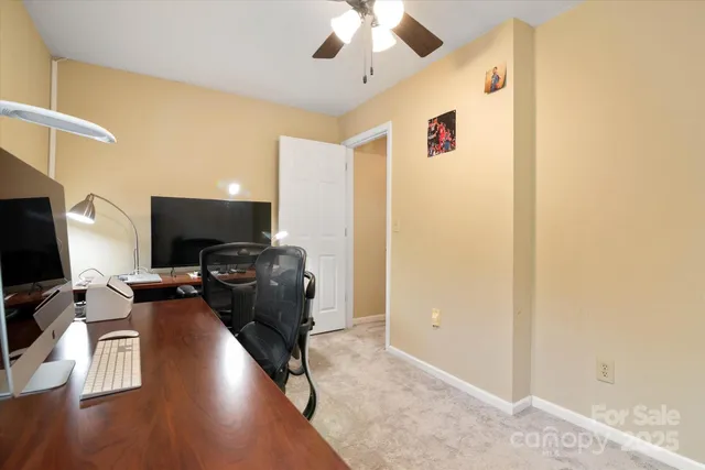 a view of a livingroom with workspace and a window