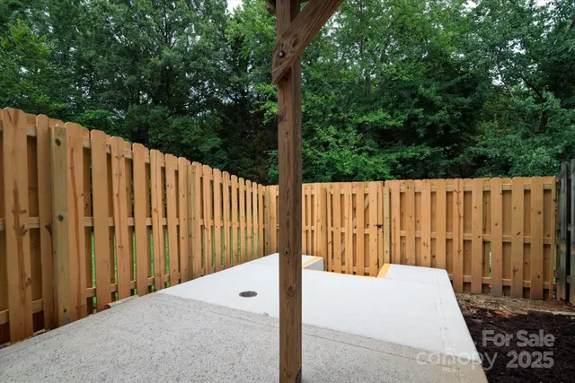 a view of a backyard with wooden fence