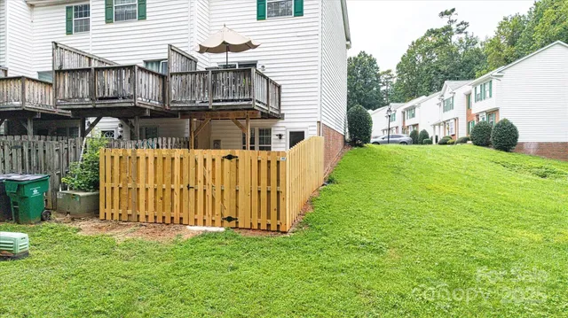 a view of a house with backyard and wooden fence