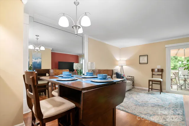 a room with stainless steel appliances kitchen island a table chairs and a refrigerator