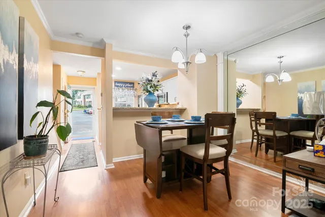 a view of a dining room with furniture a chandelier and wooden floor
