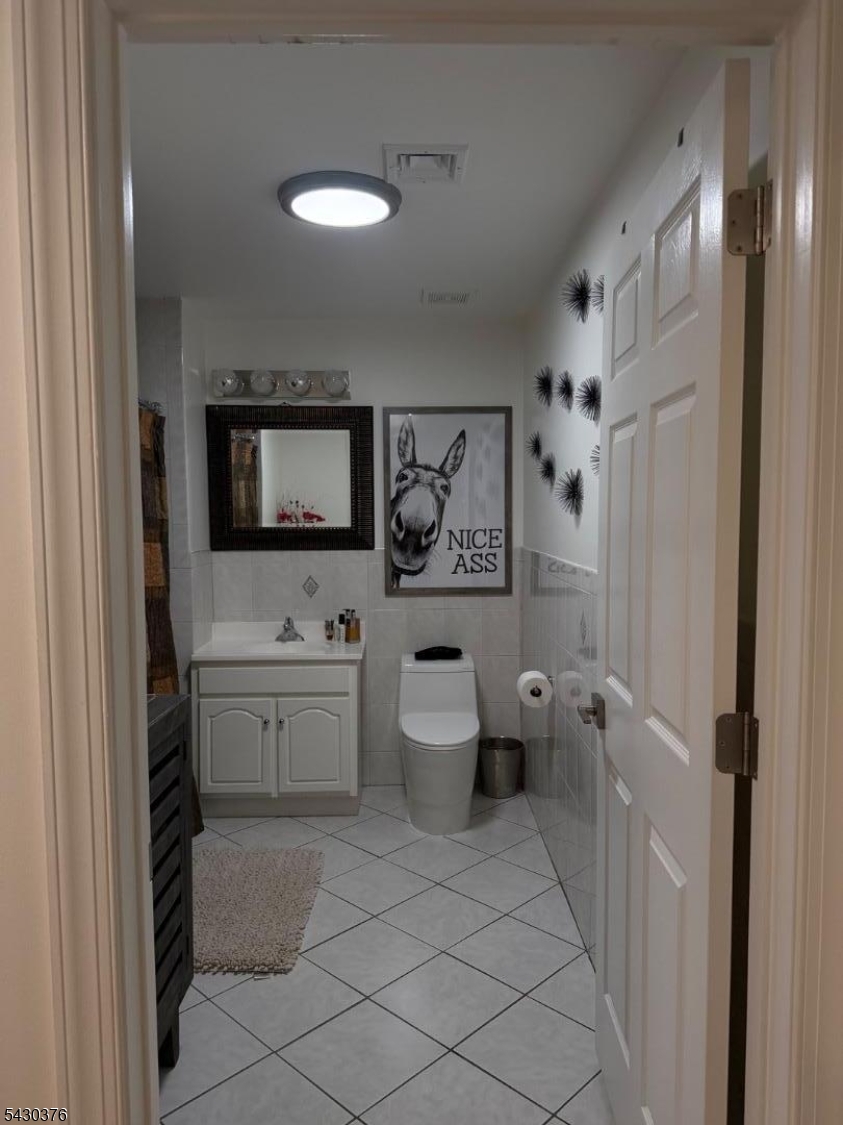 15 Tichenor Street, Unit 405 Newark, NJ 07114 - Photo 7 of 20 a bathroom with a toilet sink and mirror