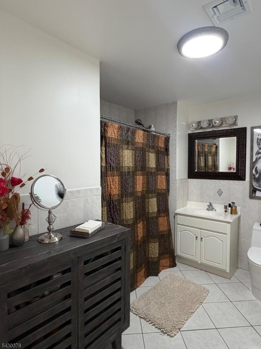 15 Tichenor Street, Unit 405 Newark, NJ 07114 - Photo 8 of 20 a bathroom with a sink a toilet and mirror