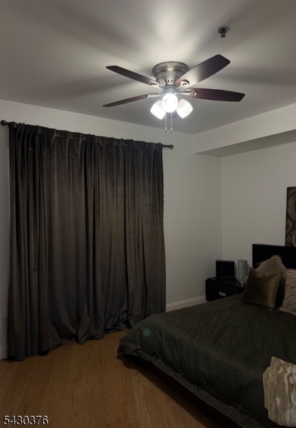 15 Tichenor Street, Unit 405 Newark, NJ 07114 - Photo 9 of 20 a bed sitting in a bedroom next to a wooden cabinet