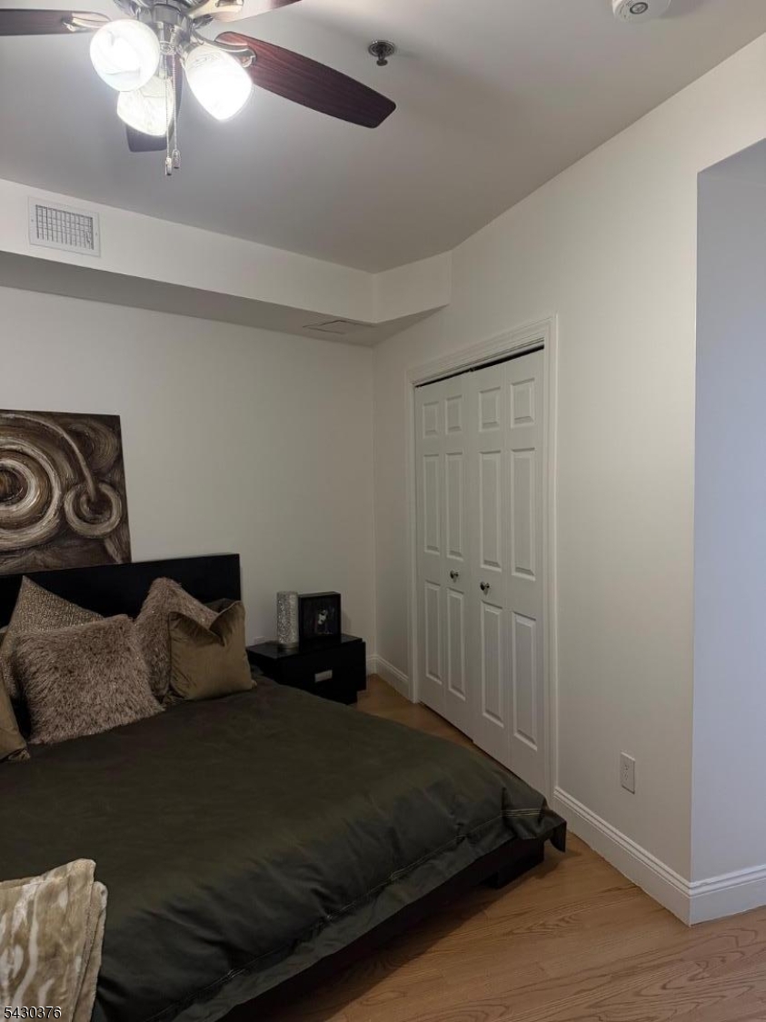 15 Tichenor Street, Unit 405 Newark, NJ 07114 - Photo 10 of 20 a bedroom with a bed and a chandelier