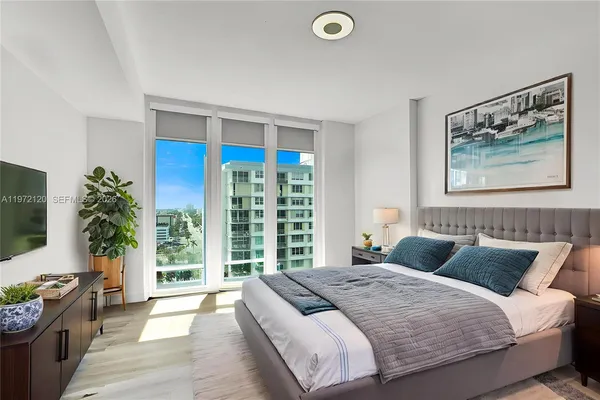 a bedroom with a balcony a bed and a flat screen tv