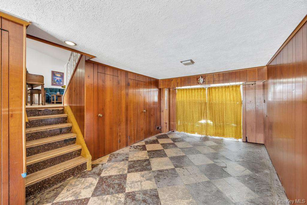 196 Haypath Road Old Bethpage, NY 11804 - Photo 17 of 21 Spare room featuring stairway, wooden walls, and a textured ceiling