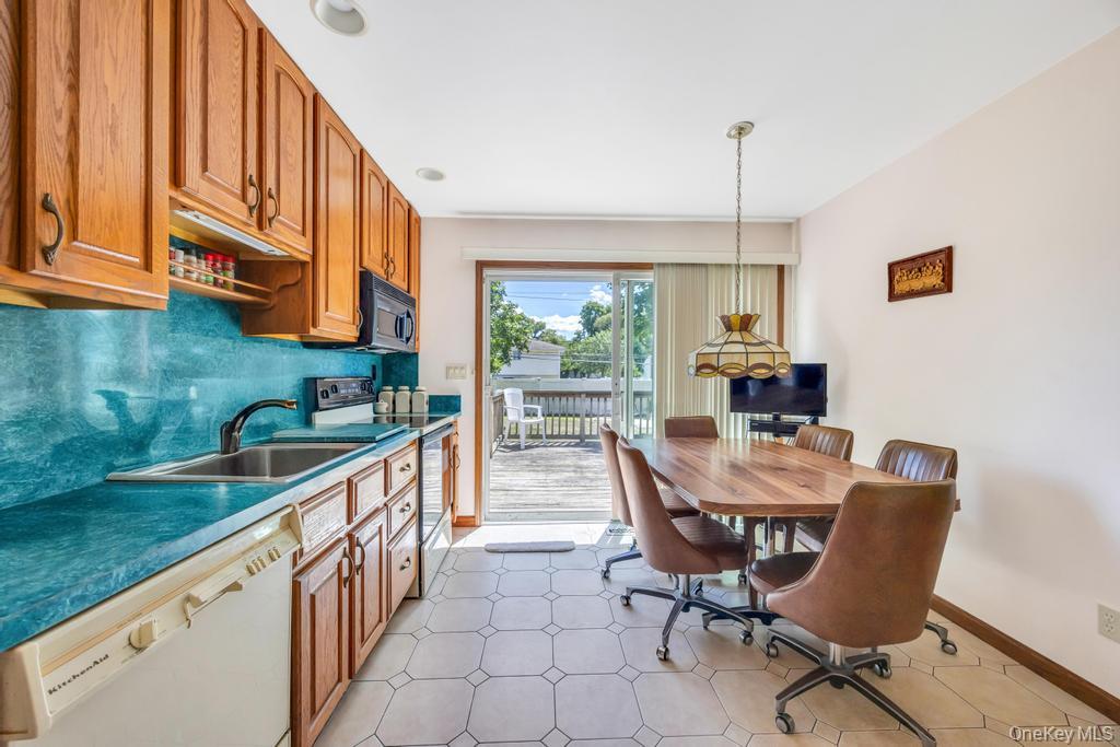196 Haypath Road Old Bethpage, NY 11804 - Photo 4 of 21 Kitchen with white appliances, brown cabinetry, backsplash, and dark countertops