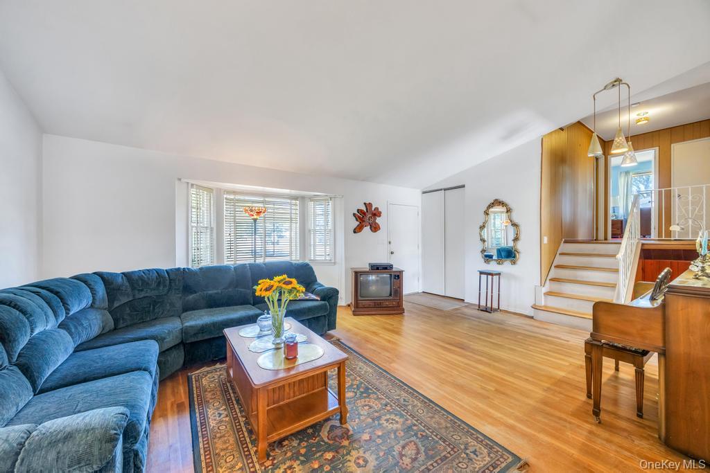 196 Haypath Road Old Bethpage, NY 11804 - Photo 9 of 21 Living area featuring light wood finished floors, stairs, and lofted ceiling