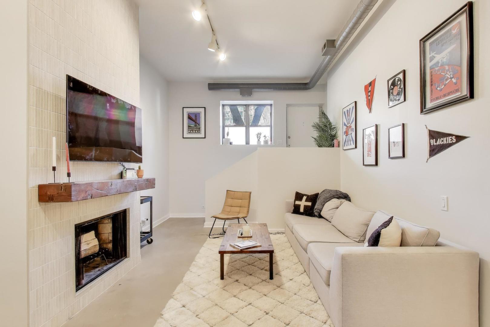 1323 West Belden Avenue, Unit E1 Chicago, IL 60614 - Photo 2 of 23 a living room with furniture a flat screen tv and a fireplace