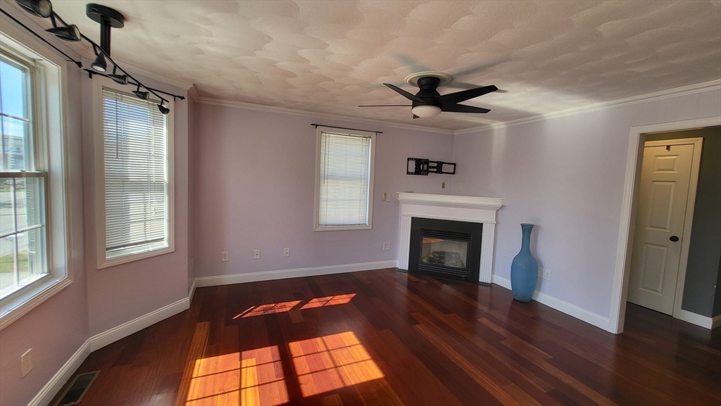 129 Manchester Street, Unit B Lowell, MA 01852 - Photo 12 of 26 a view of a livingroom with a fireplace wooden floor and windows
