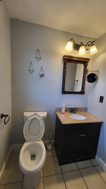 129 Manchester Street, Unit B Lowell, MA 01852 - Photo 21 of 26 a bathroom with a toilet sink and mirror
