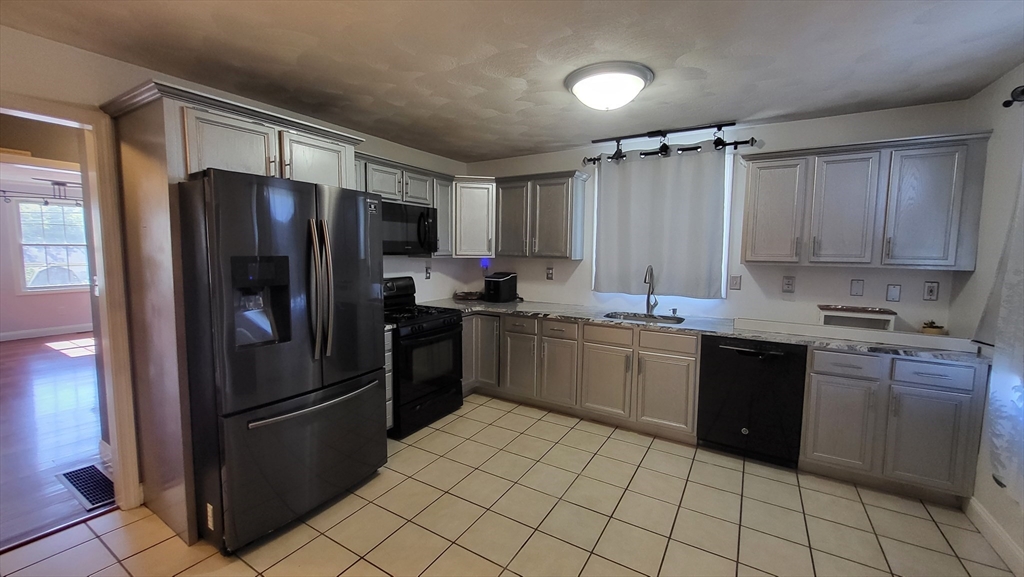 129 Manchester Street, Unit B Lowell, MA 01852 - Photo 5 of 26 a kitchen with a refrigerator and a sink