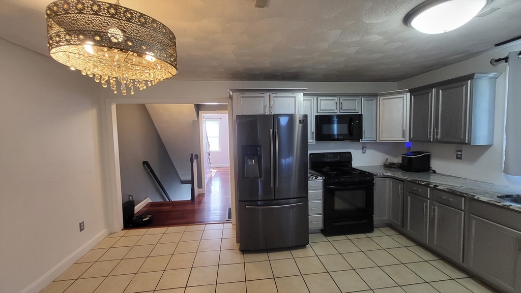 129 Manchester Street, Unit B Lowell, MA 01852 - Photo 6 of 26 a kitchen with stainless steel appliances granite countertop a refrigerator and a sink