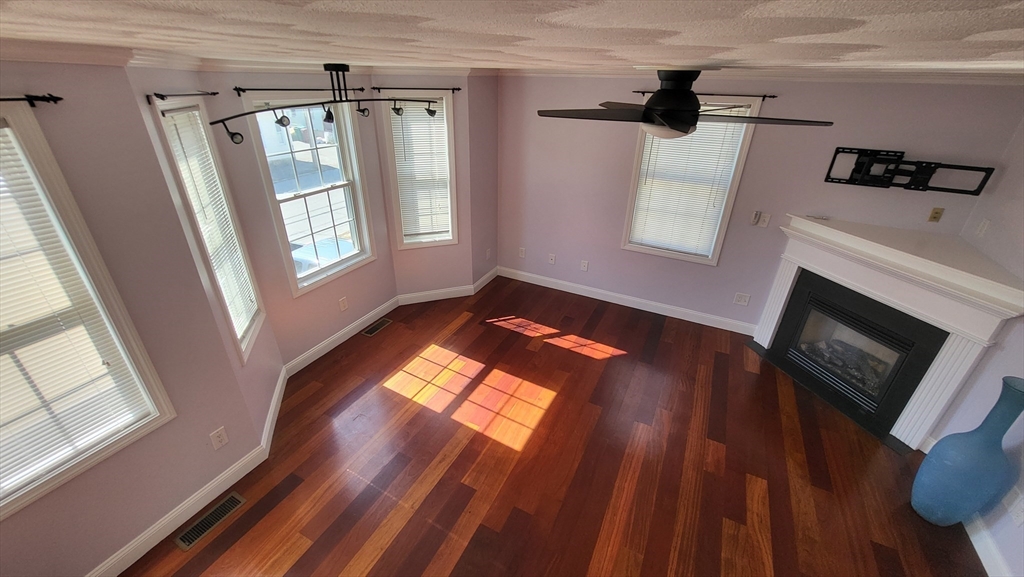 129 Manchester Street, Unit B Lowell, MA 01852 - Photo 10 of 26 a view of a livingroom with wooden floor and a fireplace