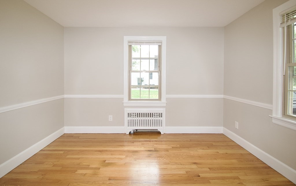 153 Gillette Avenue Springfield, MA 01118 - Photo 11 of 32 a view of an empty room with wooden floor and a window