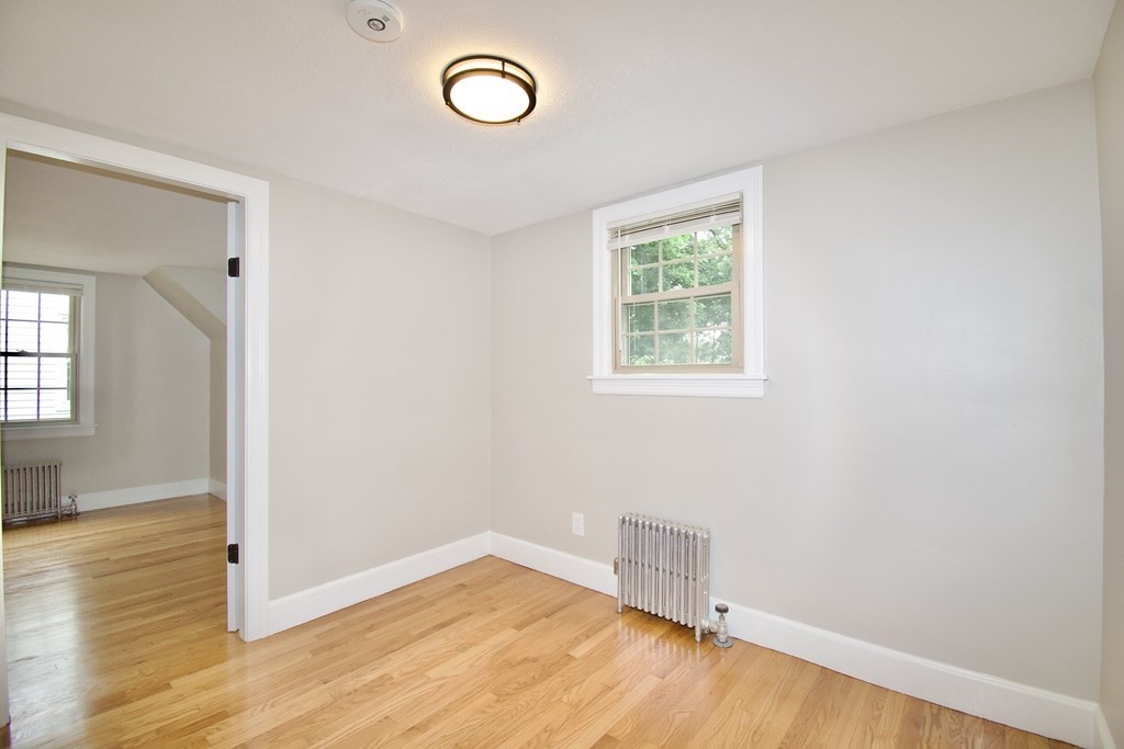 153 Gillette Avenue Springfield, MA 01118 - Photo 17 of 32 an empty room with wooden floor and windows