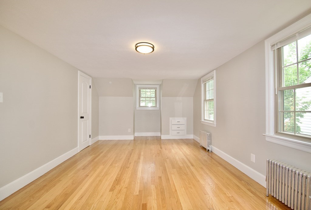 153 Gillette Avenue Springfield, MA 01118 - Photo 19 of 32 a view of an empty room with wooden floor and a window
