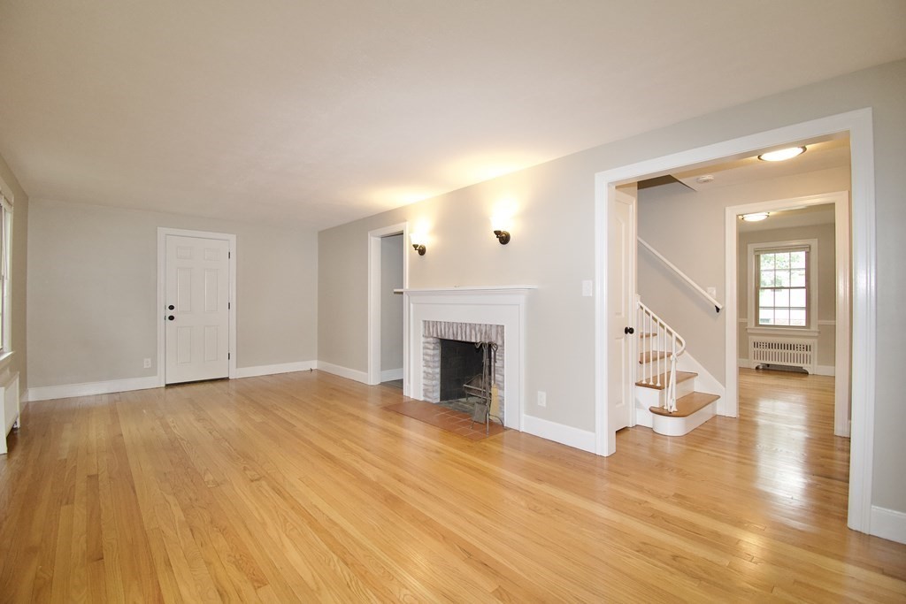 153 Gillette Avenue Springfield, MA 01118 - Photo 2 of 32 a view of an empty room with wooden floor and a fireplace