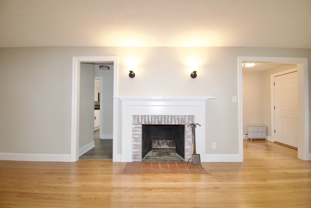 153 Gillette Avenue Springfield, MA 01118 - Photo 3 of 32 a view of an empty room with wooden floor and a fireplace