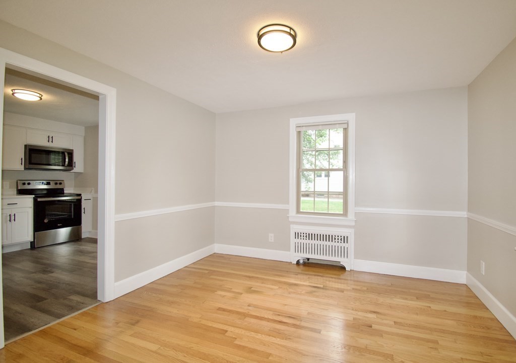 153 Gillette Avenue Springfield, MA 01118 - Photo 6 of 32 an empty room with wooden floor and windows