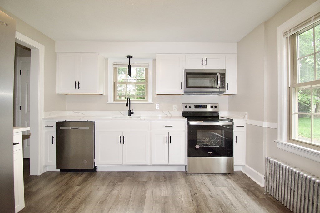 153 Gillette Avenue Springfield, MA 01118 - Photo 8 of 32 a kitchen with wooden floors and white appliances