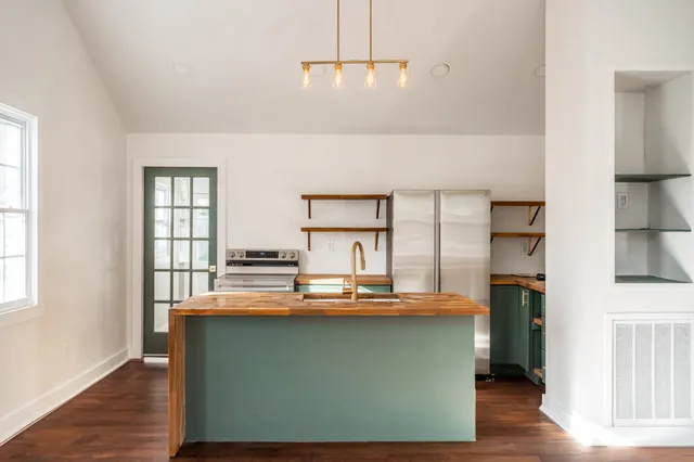 a kitchen with kitchen island granite countertop a stove and a refrigerator