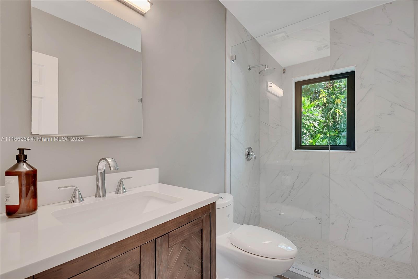 3263 Allamanda Street, Unit 3263 Miami, FL 33133 - Photo 14 of 28 a bathroom with a toilet a sink and mirror
