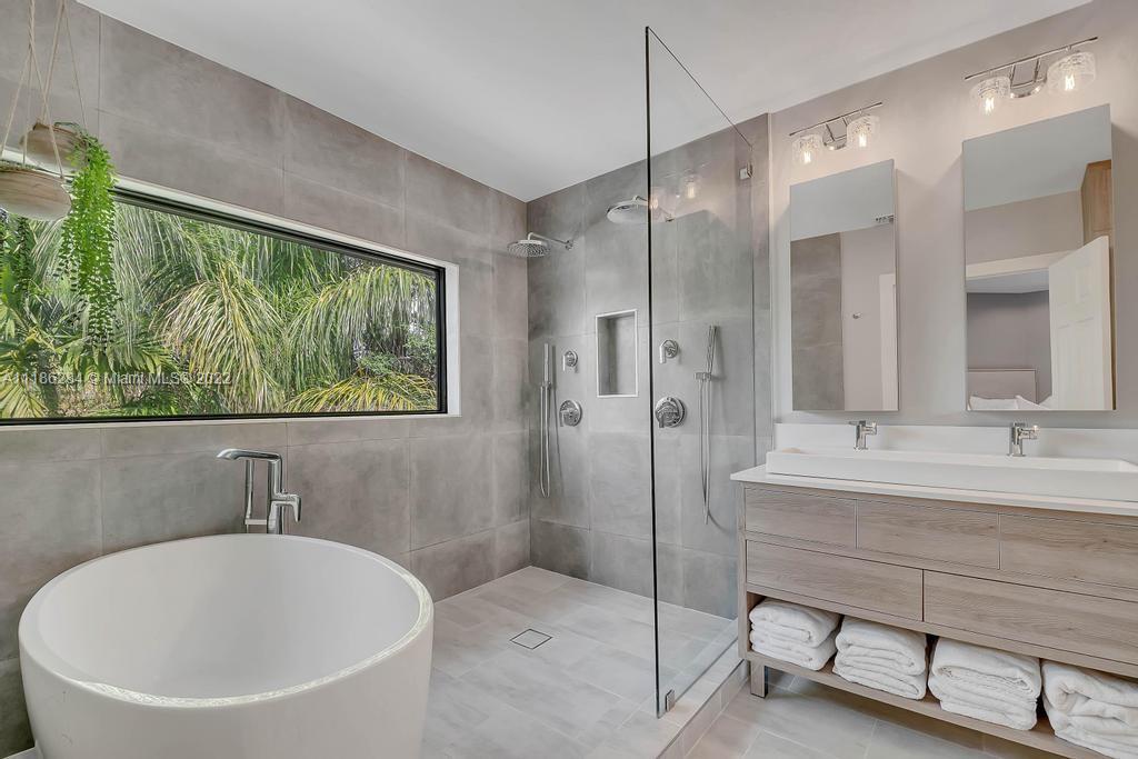 3263 Allamanda Street, Unit 3263 Miami, FL 33133 - Photo 16 of 28 a bathroom with a sink a large mirror and a bathtub