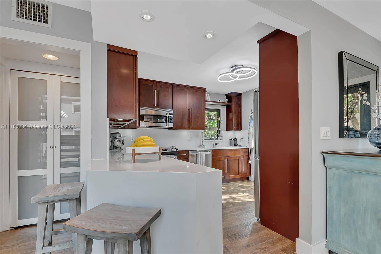 3263 Allamanda Street, Unit 3263 Miami, FL 33133 - Photo 8 of 28 a living room with stainless steel appliances furniture a rug and a kitchen view