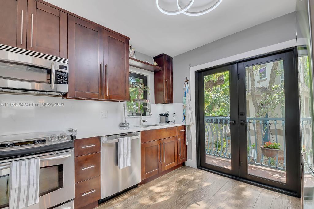 3263 Allamanda Street, Unit 3263 Miami, FL 33133 - Photo 9 of 28 a kitchen with stainless steel appliances granite countertop a stove a sink and a microwave