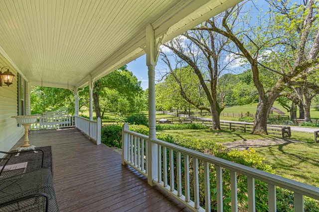 a view of a porch with wooden floor and fence