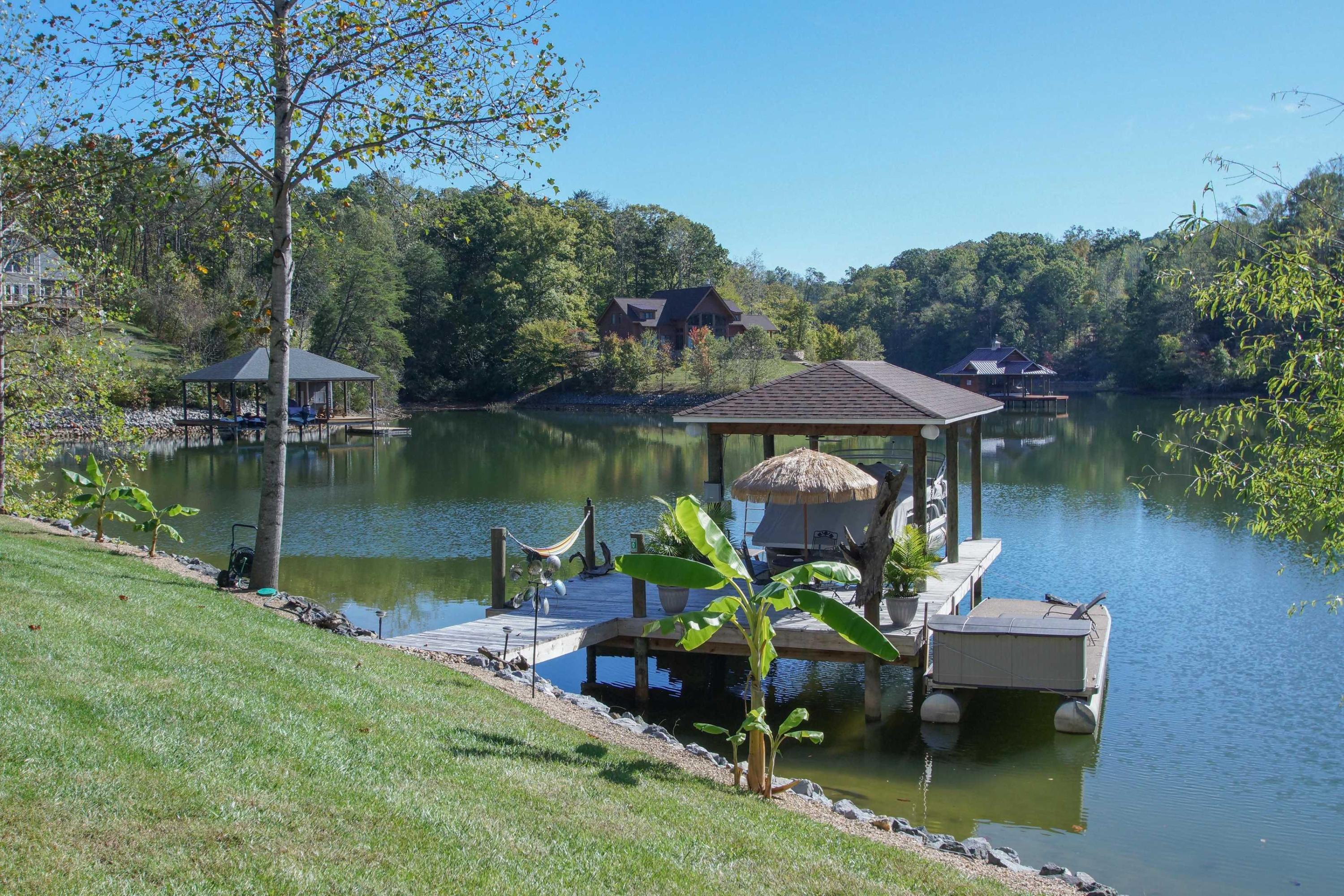 2086 Trails End Road Goodview, VA 24095 - Photo 39 of 47 a view of a lake with a table and chairs under an umbrella